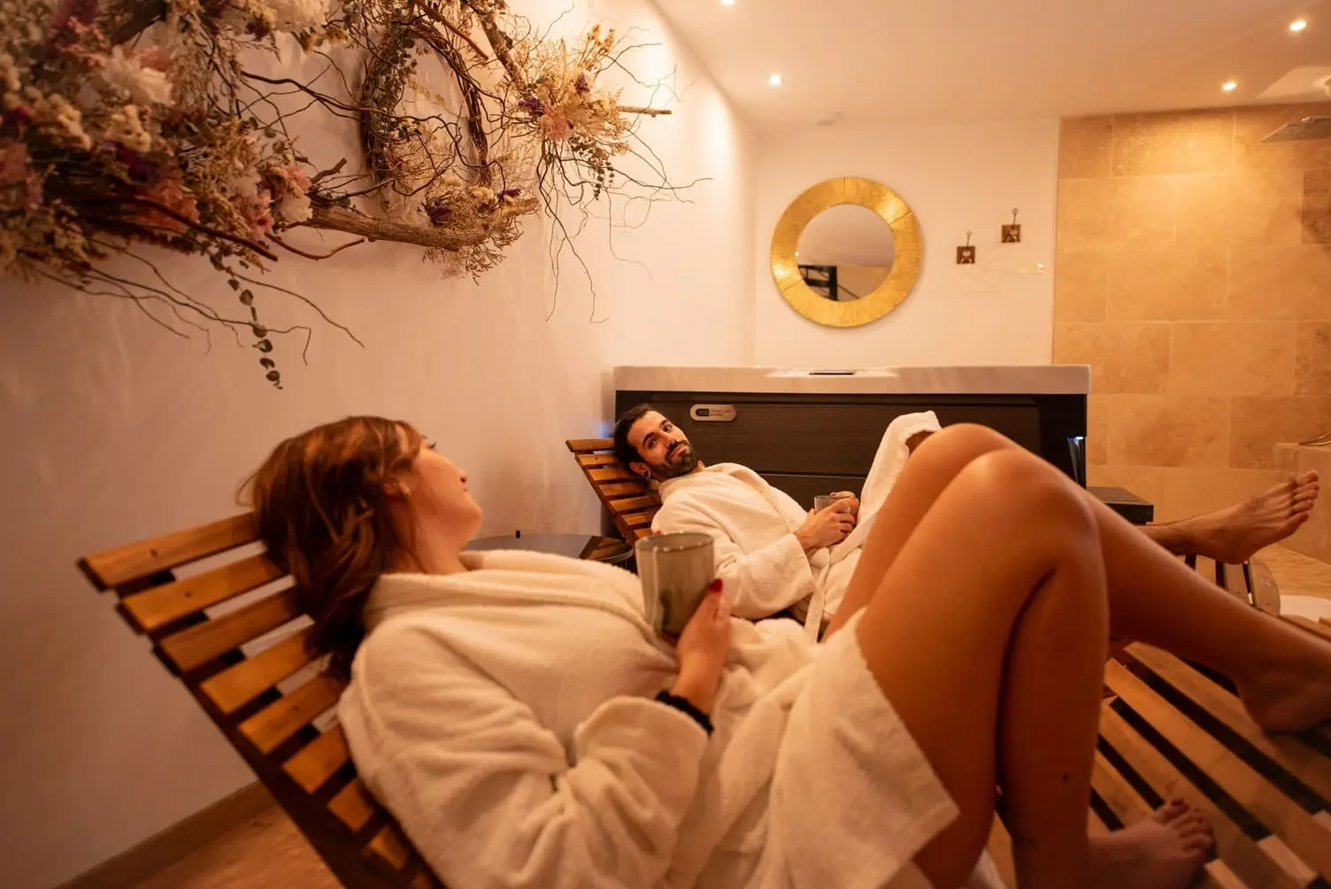 Couple qui se détend sur des transats et se regarde dans un espace de bien-être avec spa privatif